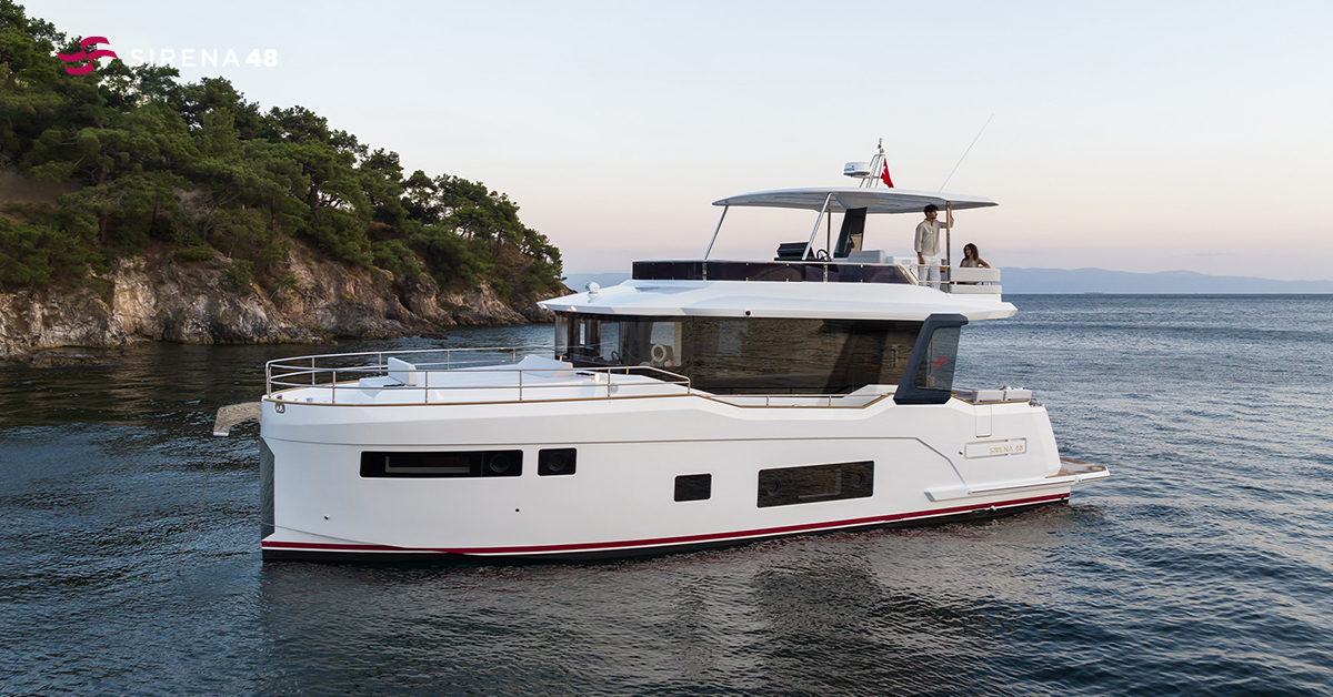 Sirena 48 yacht med flybridge, set fra siden ved klippekyst – elegant og moderne motorbåd